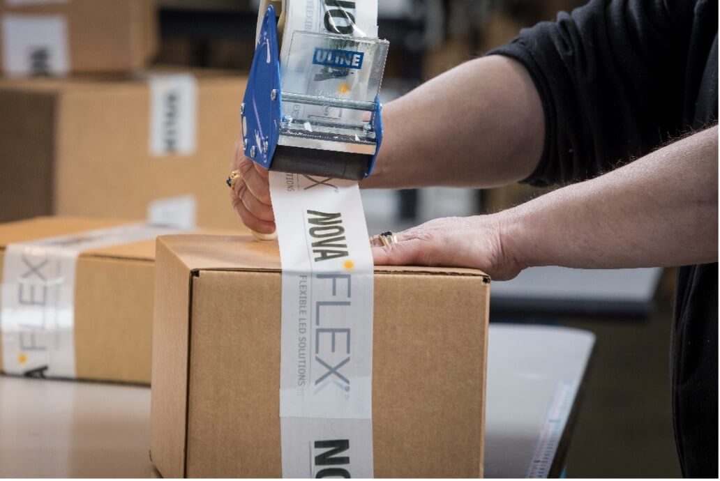 Carefully packing a shipment with NovaFlex branded tape. 